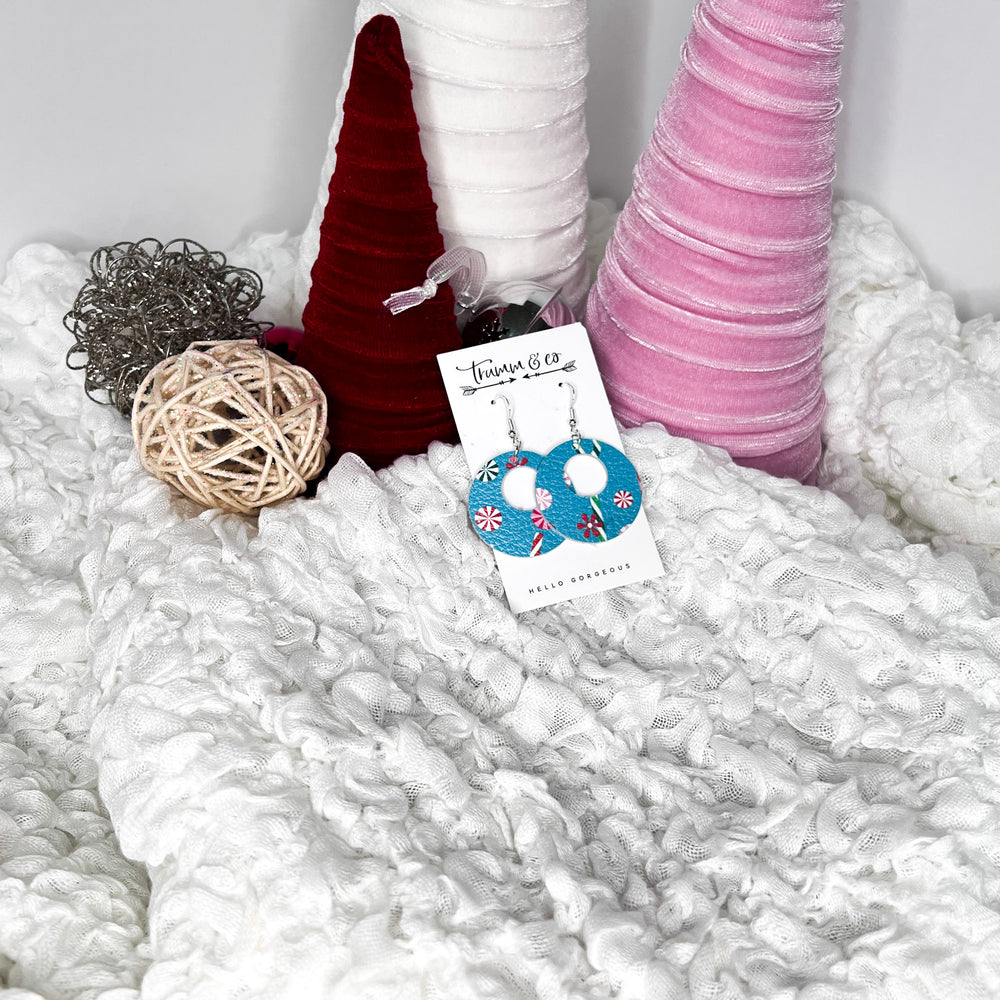 Leather festive earrings on fluffy white blanket