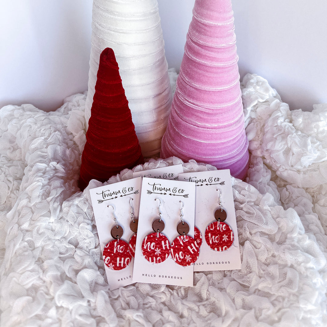 Ho ho red leather earrings on a puffy white blanket